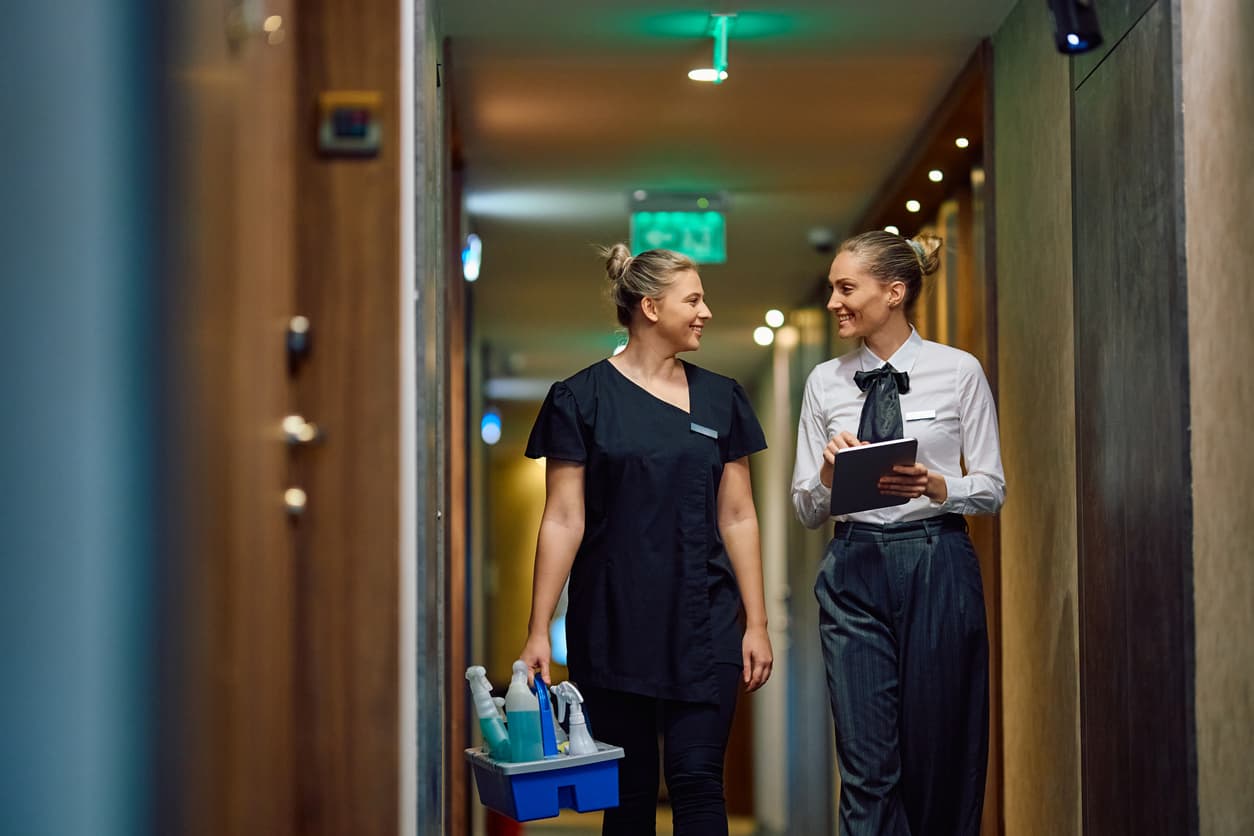 Une professionnelle StaffServices et une gouvernante échangeant dans un couloir d'hôtel