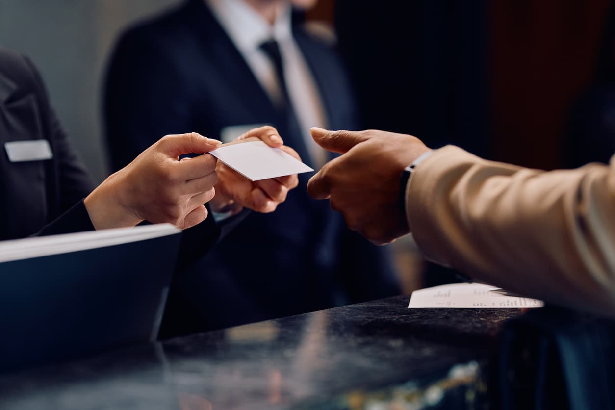 Une réceptionniste remet une carte-clé à un client au comptoir